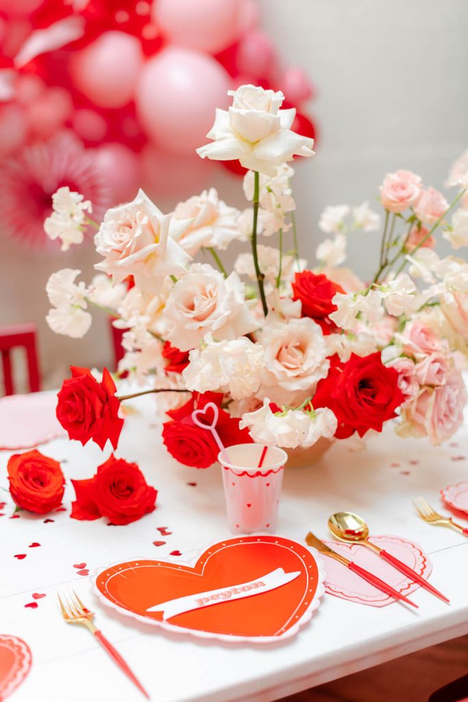 Valentine's day dinner table setting with roses and balloons